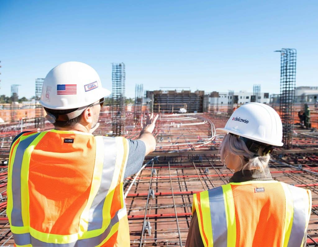 two construction workers looking at site and discussing